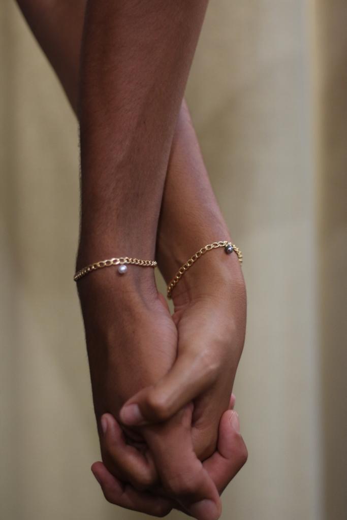 Two friends wearing matching permanent bracelets